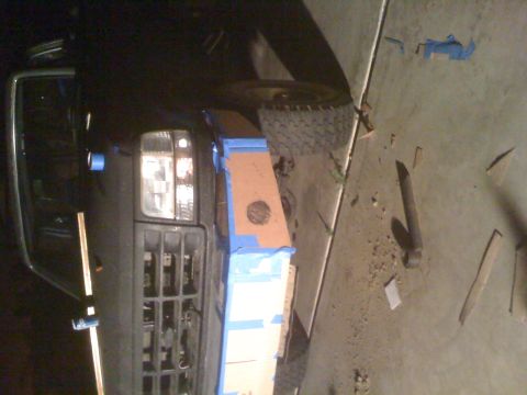 1992 Ford Bronco - Front view of a 1992 Ford Bronco being prepped for paint with masking tape and cardboard.