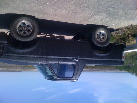 1992 Ford Bronco - This black SUV, likely from the 1980s, has a distinctive textured paint job and appears to be a two-door model.
