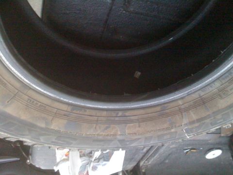 1992 Ford Bronco - A close-up view of a tire, showing its tread and sidewall markings.