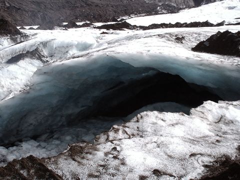 1996 Ford Bronco - A deep opening in a glacier reveals dark blue ice and snow-covered terrain.