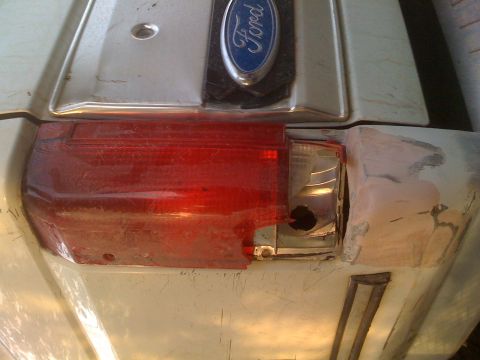 1992 Ford Bronco - Close-up of a damaged taillight and Ford emblem, suggesting a rear view of a vehicle.