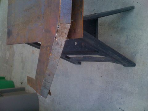 1992 Ford Bronco - This image shows a rusted metal component, possibly a bracket or frame piece, against a concrete background.