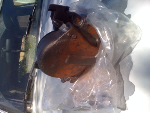 1992 Ford Bronco - An automotive part, possibly a brake caliper or similar component, is shown in a plastic bag resting on a car's windshield.