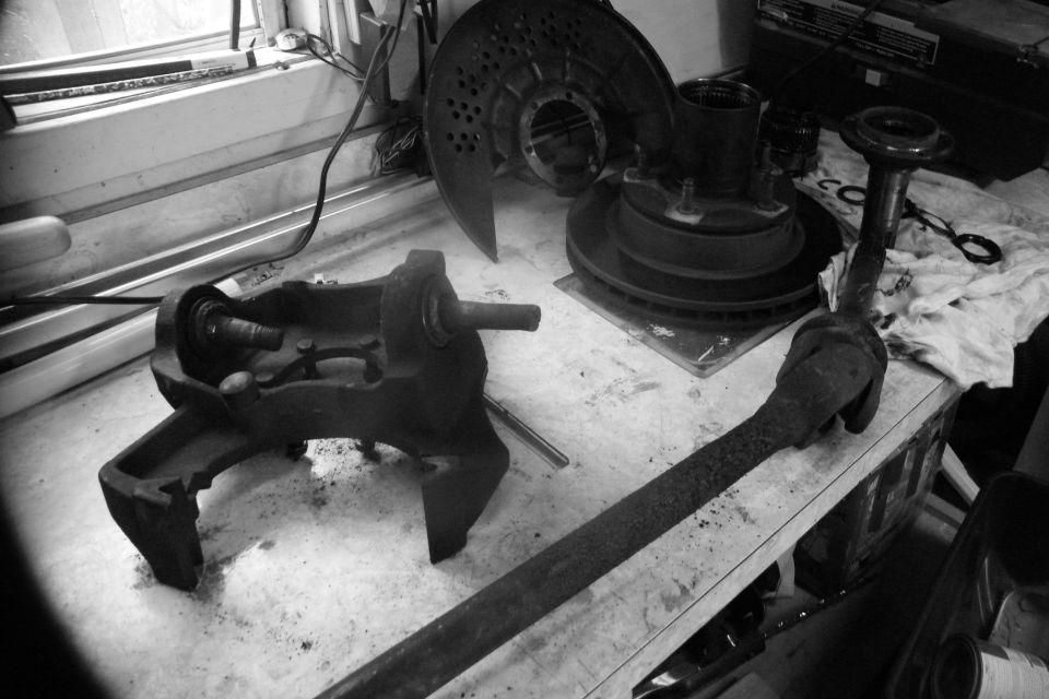 All done pulling stuff off the truck.  You should be staring a pile that looks similar to this.  4WD hub pieces and spindle in upper right, dust cover and rotor, axle and knuckle with beat up ball joints still in there.