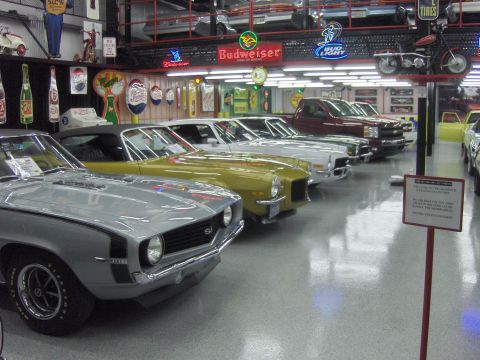 1979 Chevrolet Camaro - Several classic cars are lined up in a showroom, including a silver 1969 Chevrolet Camaro SS in the foreground.