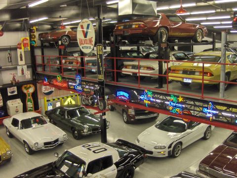 1979 Chevrolet Camaro - A variety of vehicles are displayed in a multi-level showroom, classic and modern models.