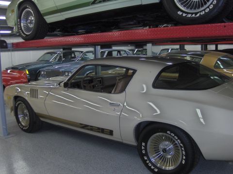 1979 Chevrolet Camaro - A beige 1979 Chevrolet Camaro Z28 is parked in a multi-level garage with other vehicles.