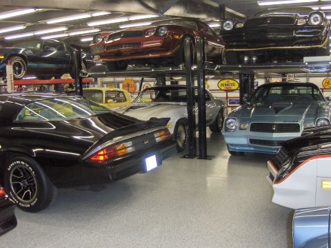 1979 Chevrolet Camaro - Multiple generations of Chevrolet Camaros are stored on lifts in a garage.