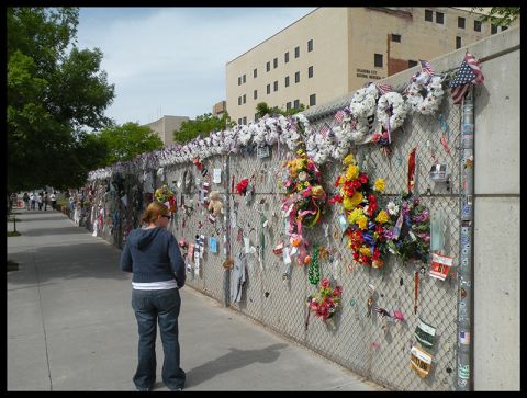 1998 Subaru Legacy - The Oklahoma City National Memorial fence is adorned with numerous tributes, including flowers and American flags.