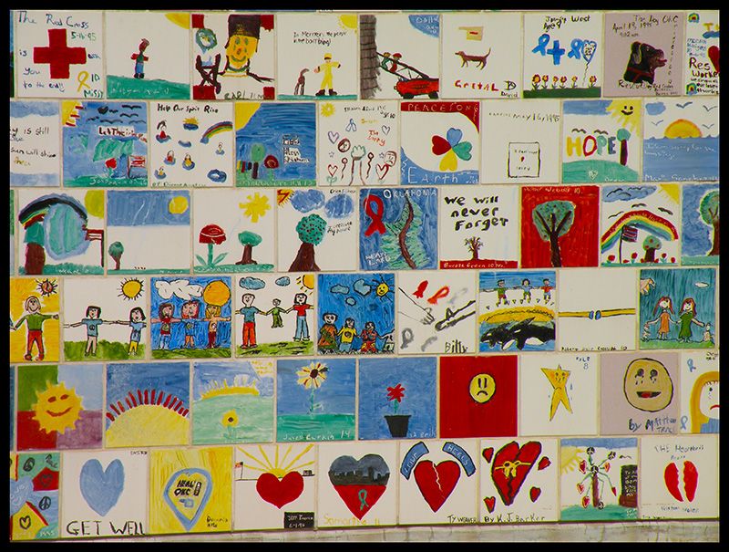 Mural of ceramic tiles depicting children's drawings of peace, hope, and remembrance