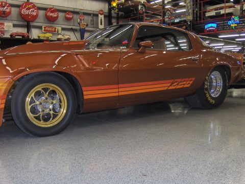 1979 Chevrolet Camaro - A brown Z28 Camaro with racing wheels and tires is parked indoors, with Coca-Cola memorabilia in the background.