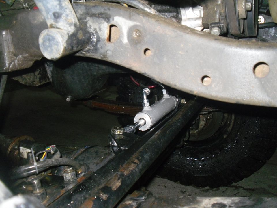 close-up of vehicle's steering linkage and hydraulic cylinder