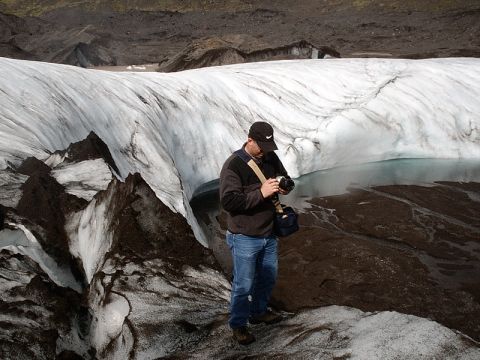 1996 Ford Bronco - A photographer stands on a glacier, examining his camera amidst the icy landscape.
