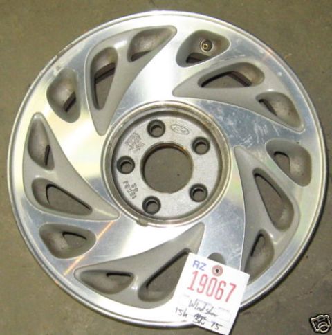 1999 Ford Crown Victoria - A single silver alloy wheel with a Ford logo is shown, with a price tag attached.