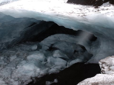 1996 Ford Bronco - The interior of an ice cave reveals intricate formations of blue-tinted ice, contrasting with deep, dark shadows.