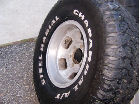 1987 Ford Bronco - A close-up view shows a steel radial tire with white lettering and a silver alloy wheel.