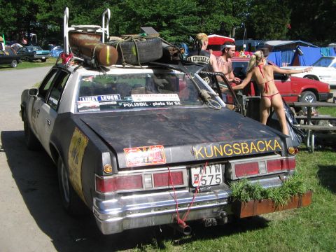 2000 Mercury Grand Marquis - This heavily modified sedan has a plant box on the rear bumper and luggage strapped to the roof.