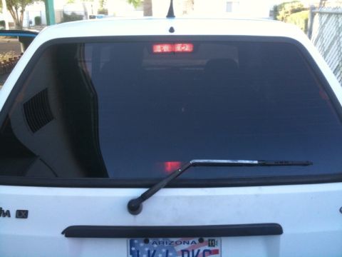 1991 Ford Festiva - Rear view of a white 1991 Ford Festiva hatchback with tinted windows and an Arizona license plate.