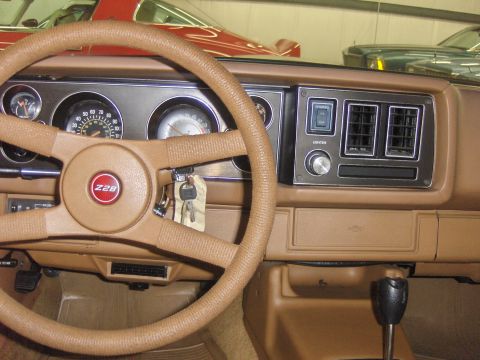 1979 Chevrolet Camaro - The dashboard of a 1979 Chevrolet Camaro Z28 features a tan interior with a Z28 emblem on the steering wheel.