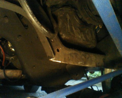 1987 Ford Bronco - Close-up of the undercarriage, showing various mechanical parts and straps.