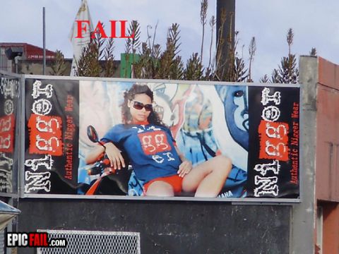 2000 Mercury Grand Marquis - A billboard displays a woman posing on a scooter, with controversial text and a 'FAIL' banner above.