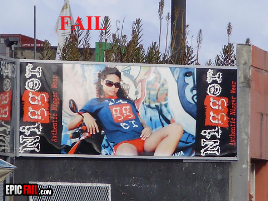 Billboard shows woman in sunglasses and t-shirt sitting on a scooter. Text on the side says 'Authentic Nigger Wear'. Red text above says 'FAIL'