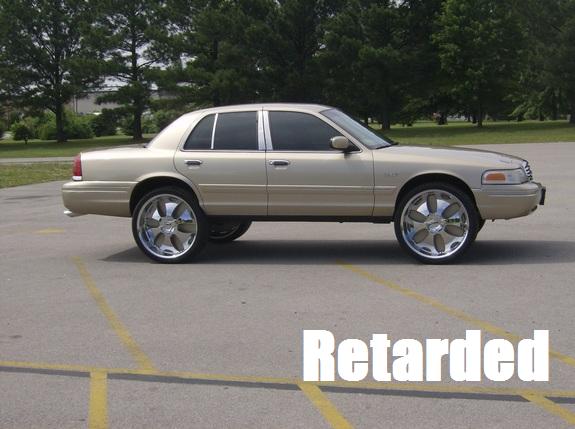 Gold sedan with large chrome rims, side view