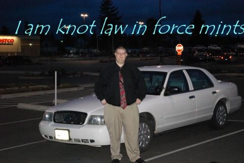 2000 Mercury Grand Marquis - A white sedan is parked in a lot at night, with a man posing in front of it. Neon text is visible in the sky above.