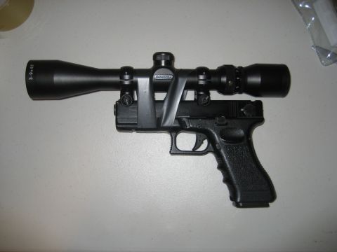 2000 Mercury Grand Marquis - Pistol with a scope mounted on top using a black strap.