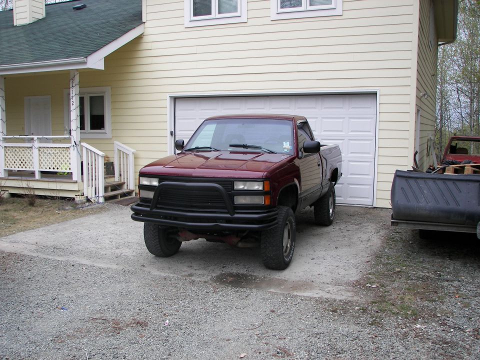 Maroon pickup truck, front view, with black bull bar parked in driveway
