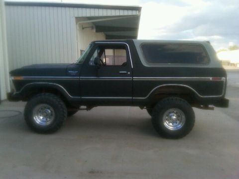 1987 Ford Bronco - This 1978 Ford Bronco features a two-tone black and grey paint scheme with prominent chrome accents along its side.