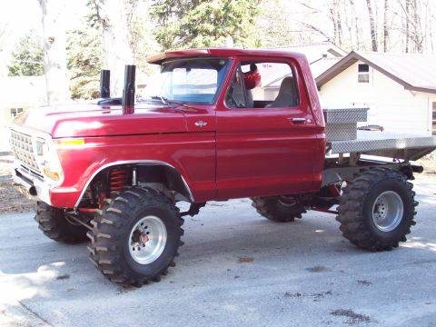 1978 Ford F-150 - This modified pickup truck features a lifted suspension and oversized tires, deviating from its original factory appearance.