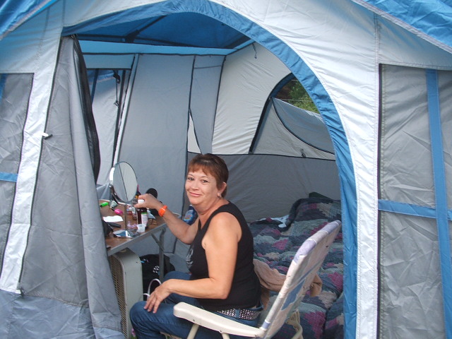 Woman applying makeup in a tent