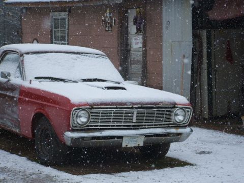 1966 Ford Ranchero - Front view of a 1966 Ford Ranchero covered in snow outside a garage.