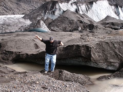 1996 Ford Bronco - A person poses on rocks amidst a glacial landscape with dark moraine and ice formations.