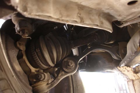 1992 Ford Taurus - Underside view of a vehicle's front suspension system, focusing on the CV joint.