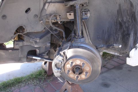 1992 Ford Taurus - Front suspension and brake assembly of a car, likely undergoing maintenance or repair.