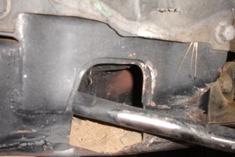 1992 Ford Taurus - Close-up of a vehicle's subframe, showing structural components and a section of exhaust pipe.