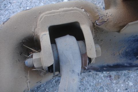 1992 Ford Taurus - A close-up view of a dusty vehicle suspension component, showing a bolt and nut assembly.