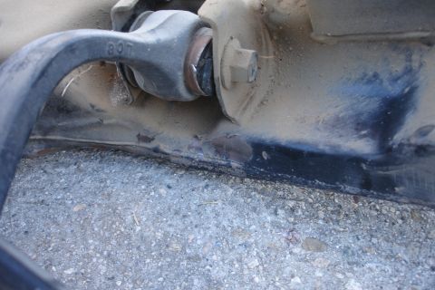 1992 Ford Taurus - A close-up view of a vehicle's suspension component, showing rust and wear on the metal frame.