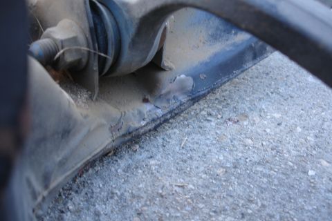1992 Ford Taurus - Detail of a worn subframe component, showing rust and damage to the metal.