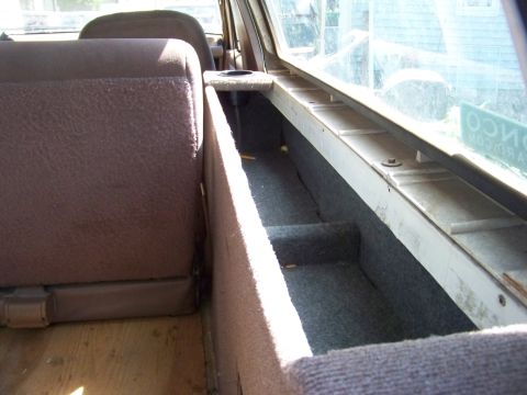 1989 Ford Bronco - A custom-built storage compartment is installed in the rear interior of a vehicle, next to the seating.
