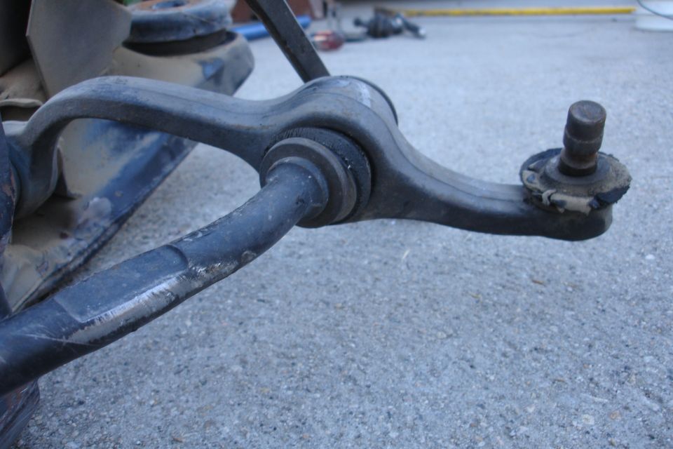 Close-up of a car's front suspension control arm and ball joint assembly