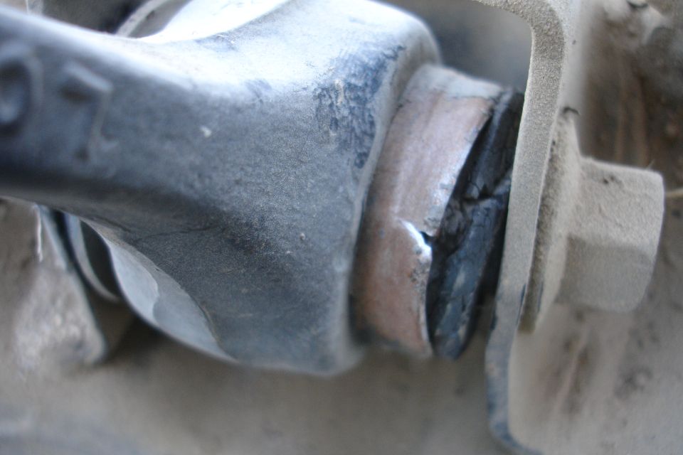 Close-up of a damaged rubber suspension bushing with metal components