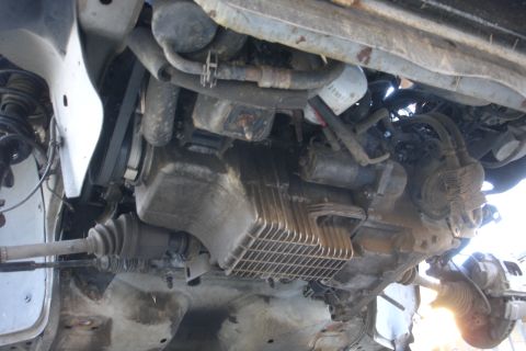 1992 Ford Taurus - Close-up view of the engine and subframe components from beneath a vehicle.