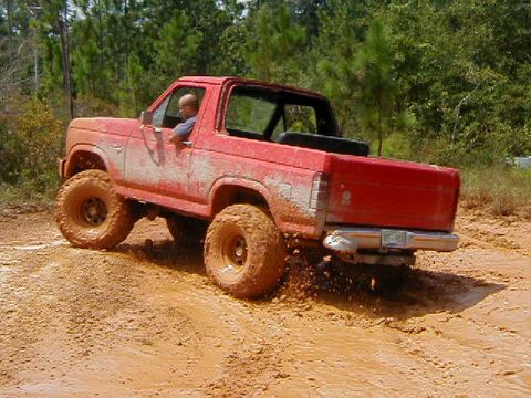 1990 Ford Bronco - 1990 Ford Bronco navigating a challenging muddy off-road course.