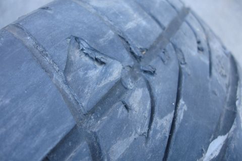 1992 Ford Taurus - Tire tread shows significant damage and wear, with pieces of rubber broken off.