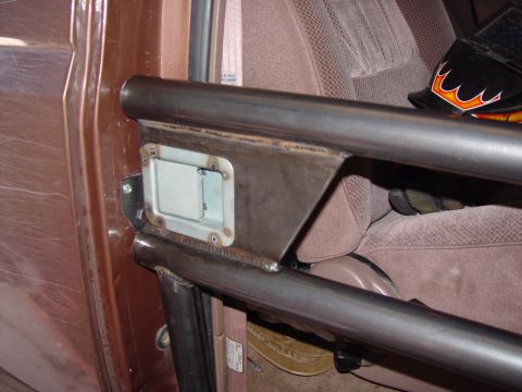 1993 Ford Bronco - Close-up of a shop-built tube door on a brown Ford Bronco, with a flush-mount paddle latch set into a welded steel plate between the upper…