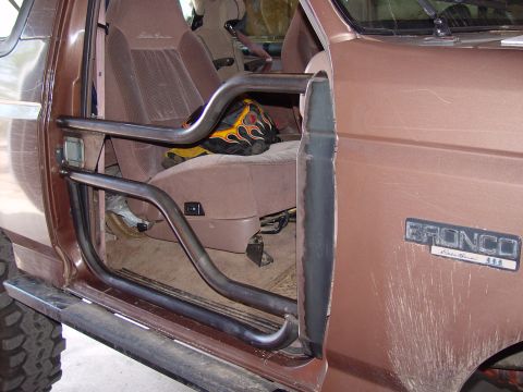 1993 Ford Bronco - Brown Ford Bronco showing tubular door and tan interior with Eddie Bauer trim and a Bronco fender badge.