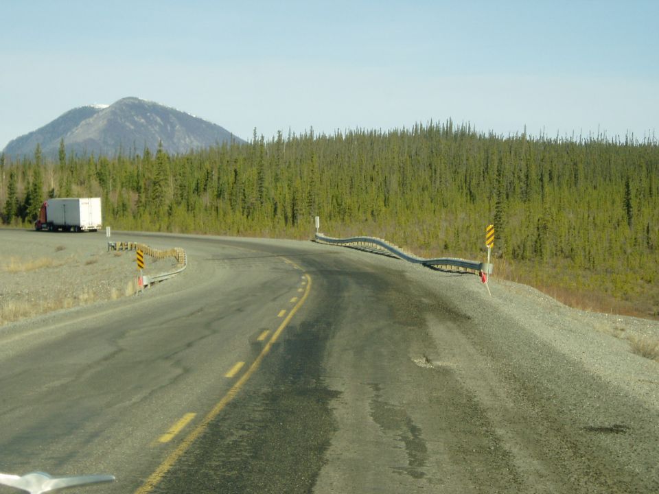 Curving highway through evergreen forest with mountain and semi truck